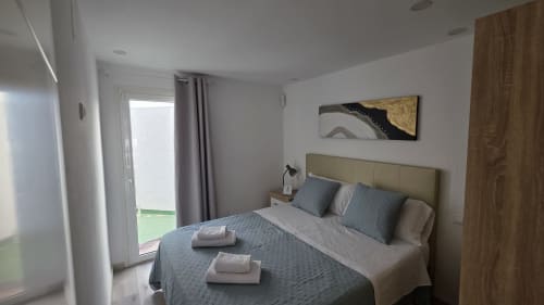 Dormitorio moderno en casa rural de Benicàssim con cama queen, terraza con vista al jardín, aire acondicionado y comodidades contemporáneas