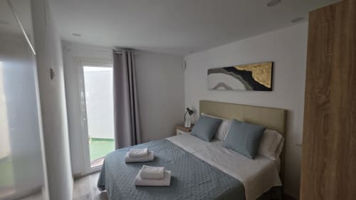 Dormitorio moderno en casa de campo de Benicàssim con vistas al jardín, cama queen, aire acondicionado y acceso a terraza