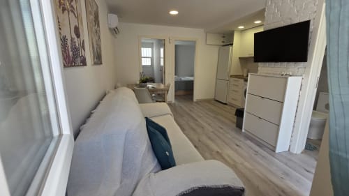 Apartamento Siesta 7 en Benicàssim: salón con sofá cama, cocina, televisión y zona de comedor