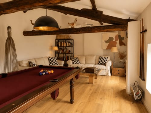 Rustic game room at El Escondite De Pedro Malillo with pool table, beam ceilings, and cream seating in Candeleda