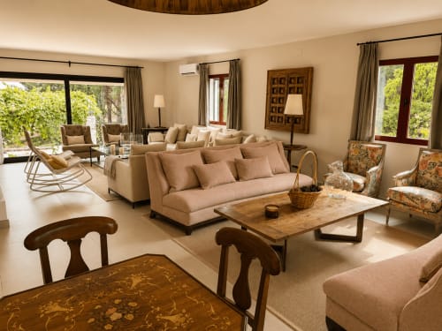 Spacious living room at El Escondite De Pedro Malillo with beige sofas, wooden furniture, and large windows in Candeleda