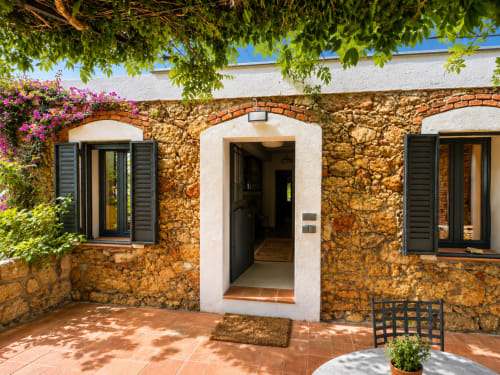 Stone cottage terrace at El Escondite De Pedro Malillo in Candeleda with arched doorway and flowering bougainvillea