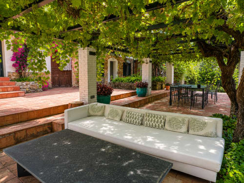 Shaded courtyard seating at El Escondite De Pedro Malillo in Candeleda with ivy-covered pergola and white sofa