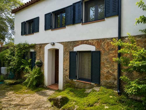 El Escondite De Pedro Malillo entrance with stone facade and black shutters in Candeleda, Spain