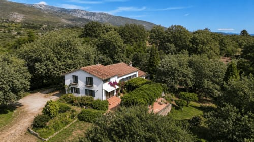 Aerial view of Casa Alardos villa in Candeleda, white house with terracotta roof surrounded by olive trees and mountains