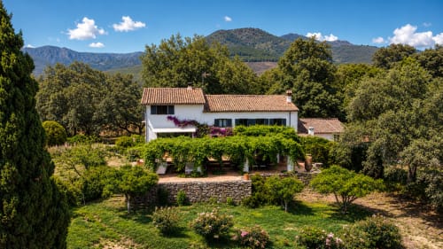 Casa Alardos villa in Candeleda with white walls, terracotta roof, surrounded by gardens and mountains