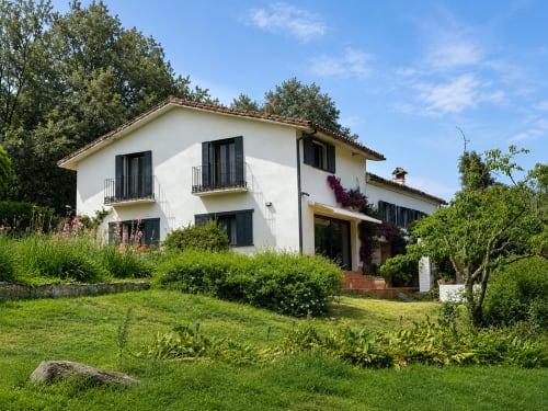 Casa Alardos villa in Candeleda with white facade, black shutters, manicured gardens and terraces