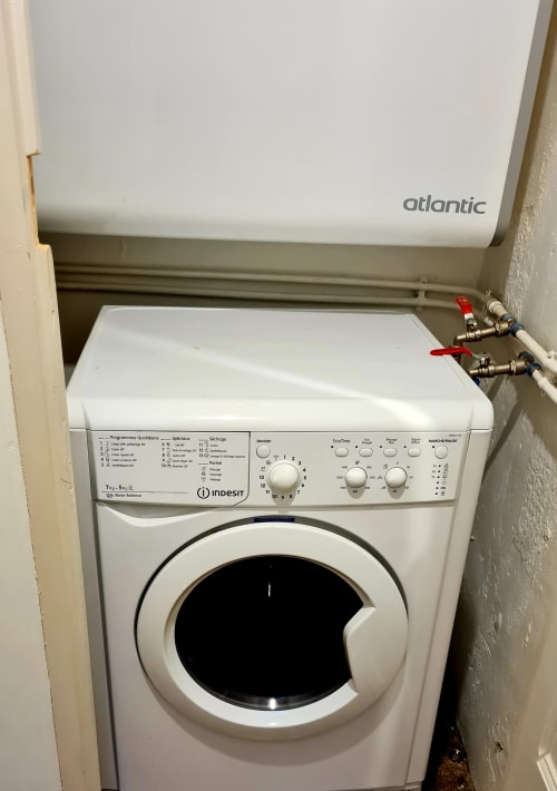Indesit washing machine in Les Suites de Montigny apartment, Aix-en-Provence, with Atlantic water heater above