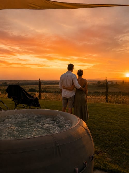 Coppia che guarda il tramonto dalla vasca idromassaggio a Il Poggio di Musignano a Canino, Italia