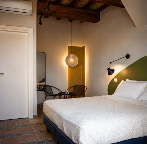 Camera da letto moderna a Il Poggio di Musignano a Canino con testata verde, illuminazione a sospensione e design minimalista