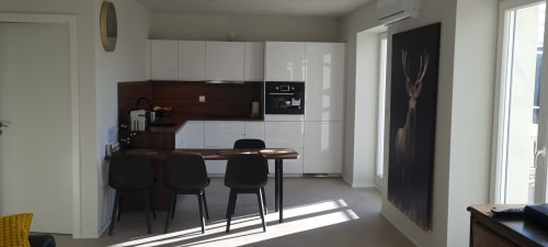 Cuisine et salle à manger modernes aux Gîtes d'Avalon à Thannenkirch avec mobilier blanc et table de repas foncée