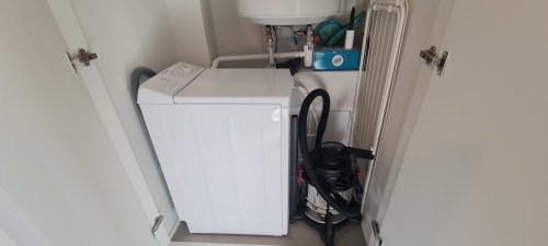 Petit buanderie à Les Gîtes d'Avalon avec lave-linge et rangements