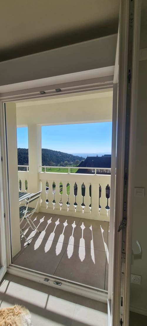 Vue de la terrasse des Gîtes d'Avalon à Thannenkirch surplombant les montagnes et les vallées verdoyantes