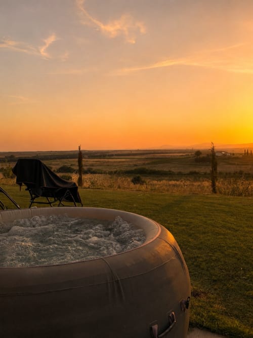 Vasca idromassaggio esterna al tramonto con vista sulla campagna toscana e lettino, Il Poggio di Musignano, Canino Italia