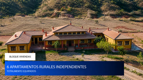 Vista aérea de coloridos apartamentos rurales en Finca El Arroyo, Alcaraz, España, con tejados de terracota y jardines paisajísticos
