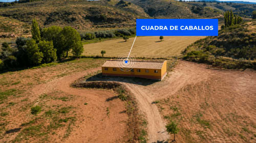 Vista aérea del edificio amarillo Cuadra de Caballos en Finca El Arroyo, Alcaraz, España con paisaje rural