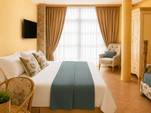 Espacioso apartamento hotelero en Baiona con vista a la ciudad, cama, sillón, TV de pantalla plana y cortinas doradas