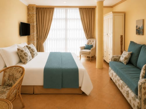 Espacioso apartamento Misiño en hotel Holibai, Baiona: cama queen, sofá, vistas a la terraza y amenidades modernas