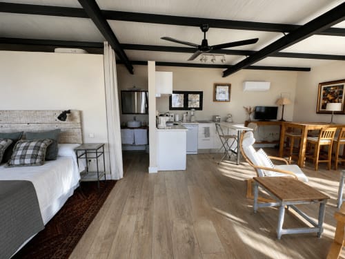 Acogedor estudio en El Escondite De Pedro Malillo, Candeleda: cama, cocina americana, comedor y vigas de madera