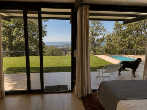 Lujosa habitación en El Escondite De Pedro Malillo en Candeleda con vistas panorámicas, acceso a piscina y perro negro en la terraza