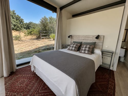 Habitación moderna en El Escondite De Pedro Malillo, Candeleda, con cama, almohadas de tartán, vistas rurales y acceso a patio
