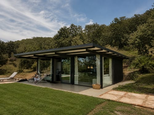 Moderno pabellón de cristal en El Escondite De Pedro Malillo en Candeleda con terraza con vistas al jardín verde y la ladera boscosa