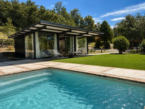 Villa moderna con piscina turquesa, tumbonas y arquitectura negra en Casa La Palmera de Candeleda