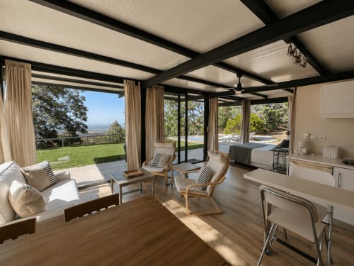 Amplia sala de estar en Casa La Palmera con vistas panorámicas al valle, mobiliario moderno y acceso directo al jardín