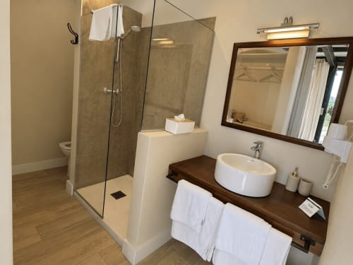 Baño moderno en villa Casa La Palmera con ducha abierta, lavamanos tipo recipiente y vanidad de madera oscura en El Escondite De Pedro