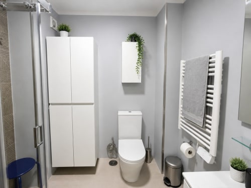 Baño moderno del hotel Holibai en Baiona con sanitarios blancos, toallero y plantas en maceta