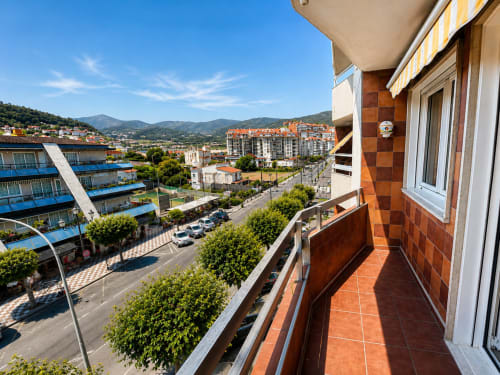 Balcón del hotel Holibai con vistas a Baiona, montañas, edificios y cielo azul