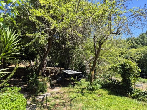 Zona de descanso en jardín sombreado con árboles maduros en el hotel rural Aldea Rural Pazos De Arenteiro en España