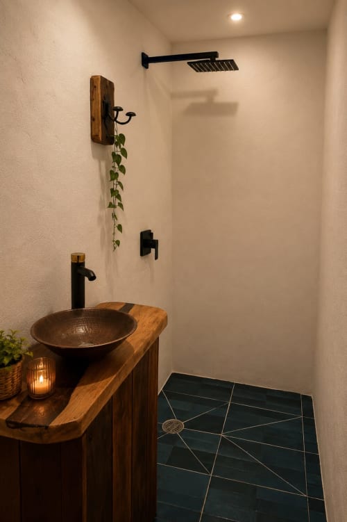 Modern bathroom in Isla Mujeres cottage with wooden vanity, copper bowl sink, black fixtures, and rainfall showerhead