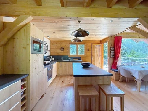 Cuisine et salle à manger spacieuses en bois avec vue sur les montagnes aux Tanières de Montgenèvre
