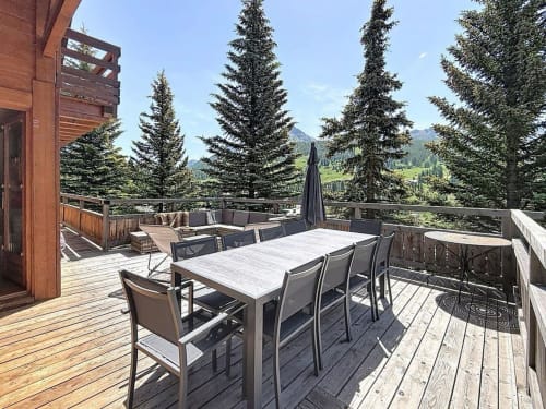 Spacieuse terrasse de montagne aux Tanières de Montgenèvre avec table à manger, salon et vue sur les Alpes