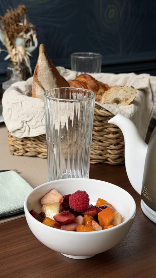 Table de petit-déjeuner élégante à L'ODE A PIERRE avec compote de fruits frais, panier de pain et verre d'eau à Dax, France