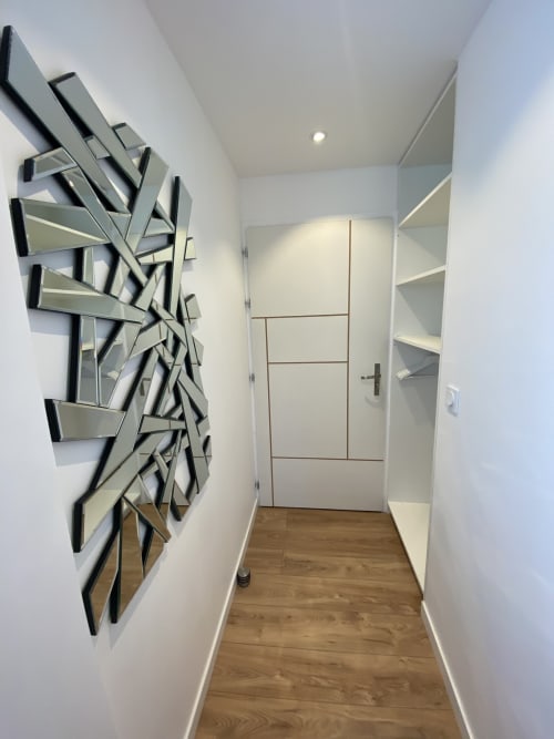 Couloir moderne avec art miroir géométrique à La Maison Blanche B&B, Bouguenais, mobilier blanc et parquet.