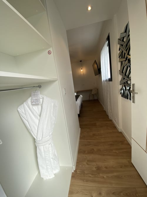 Couloir moderne d'hôtel avec peignoirs blancs, parquet et décoration murale à La Maison Blanche, Bouguenais