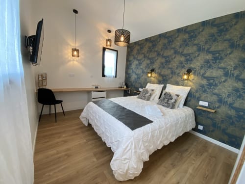 Chambre moderne à La Maison Blanche B&B à Bouguenais avec papier peint botanique, luminaires suspendus et bureau de travail