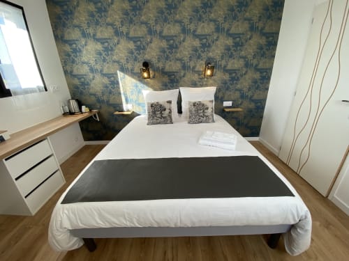 Chambre moderne à La Maison Blanche B&B à Bouguenais avec papier peint bleu à motifs et literie blanche