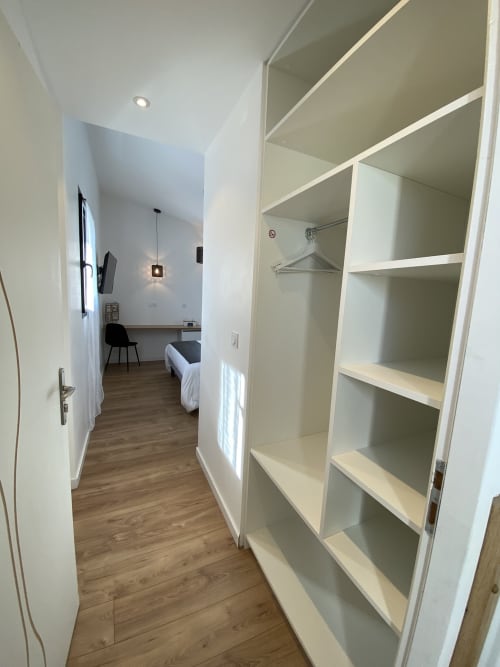 Dressing moderne avec rangements blancs à La Maison Blanche B&B à Bouguenais, France