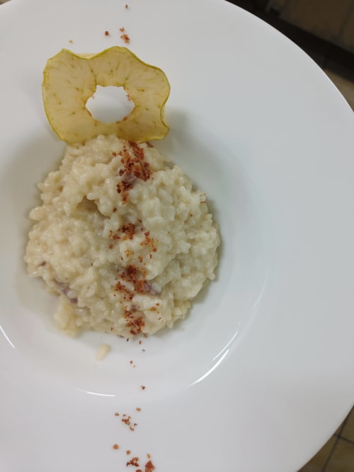 Creamy risotto dish at Hotel Ristorante alle Querce in Castelbuono, topped with crispy apple chip garnish