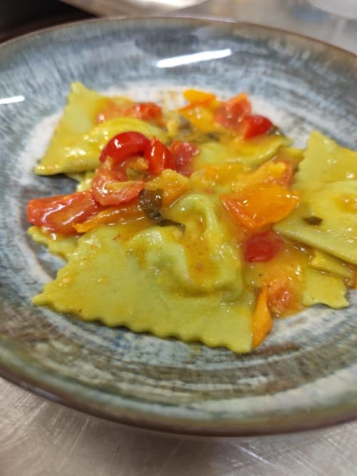 Colorful ravioli with red peppers and vegetables on a ceramic plate at Hotel Ristorante alle Querce, Castelbuono
