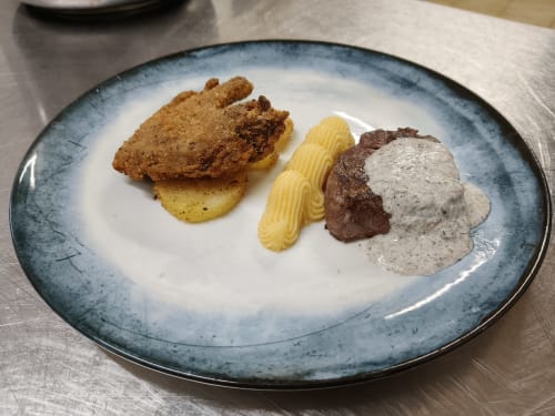 Gourmet plated dish at Hotel Ristorante alle Querce in Castelbuono featuring fried cutlet, potato, pasta, and creamy sauce