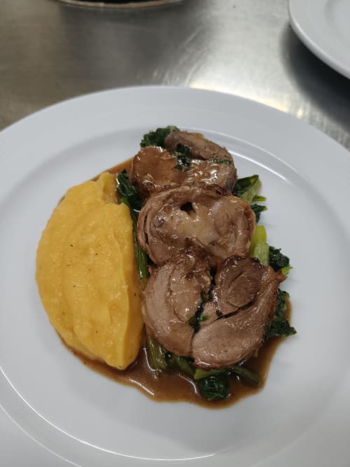 Plated meat dish with potato and greens at Hotel Ristorante alle Querce, Castelbuono