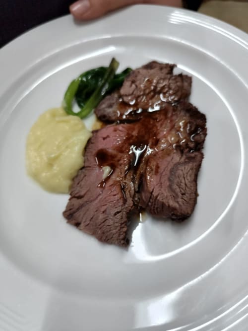 Sliced beef steak with mashed potatoes and green vegetables served at Hotel Ristorante alle Querce in Castelbuono
