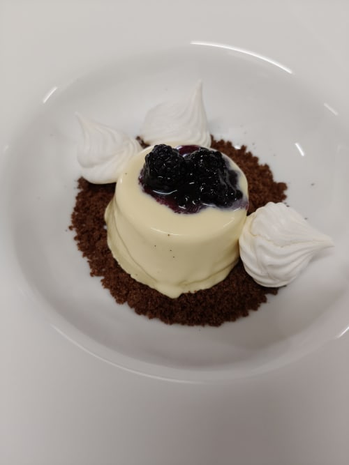 Elegant chocolate dessert with cream, berries, and meringue at Hotel Ristorante alle Querce in Castelbuono