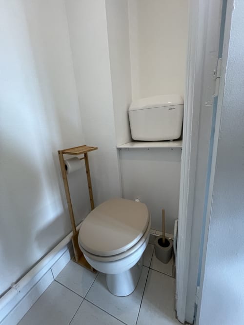 Toilettes compactes avec porte-serviettes en bois et poubelle à Studio L'île verte, Guimiliau