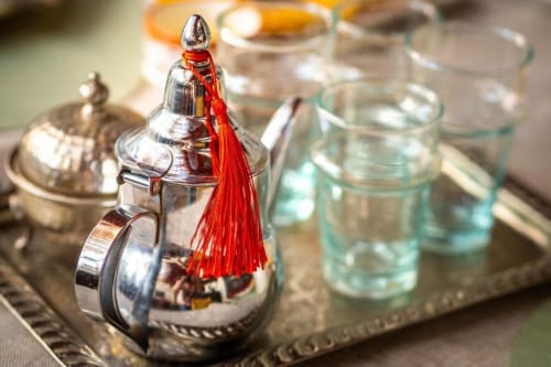 Théière en argent ouvragée avec gland rouge et verres à Villa El Gada à Marrakech