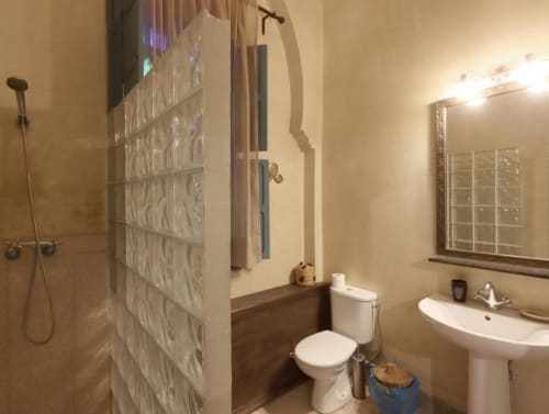 Salle de bains moderne de la Suite Triple Villa El Gada, Marrakech, avec lavabo sur colonne blanc, toilettes et douche vitrée